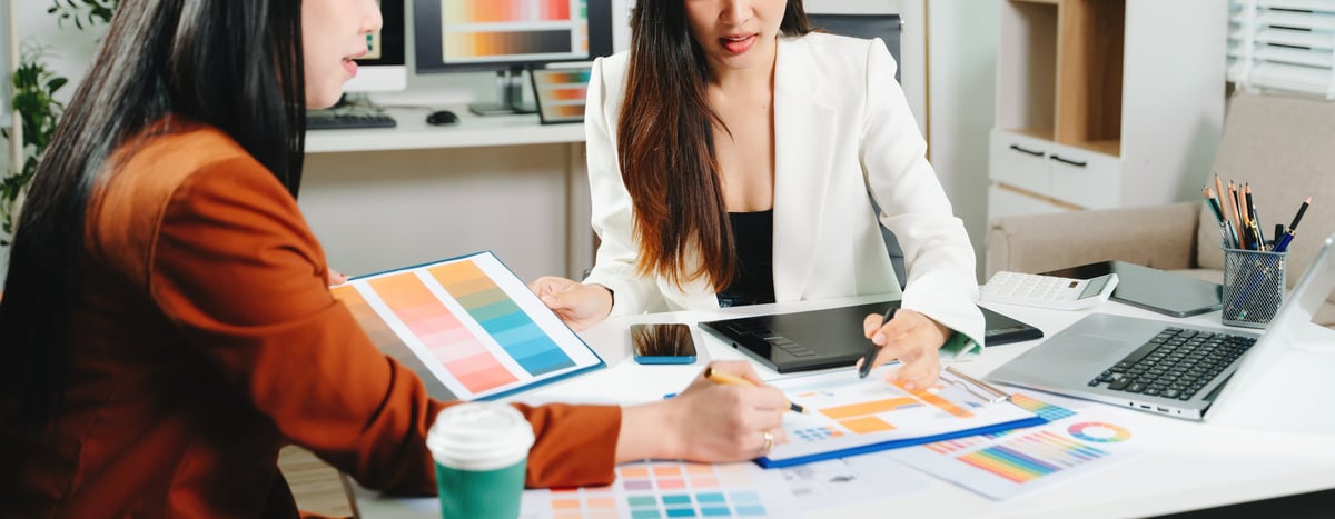 Two designers reviewing a colour palette and interface layout in a studio